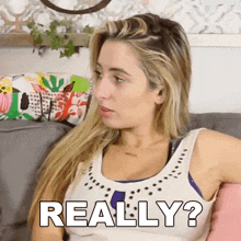 a woman is sitting on a couch with the words really written on her chest