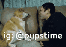 a man and a dog are sitting on a couch and the dog is looking at the man 's face