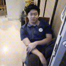a man is sitting in a chair with his arms crossed in front of a mirror
