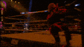 a wrestler is walking out of a wrestling ring with a sign behind him that says herman