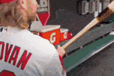 a baseball player named swan is holding a bat in his hand