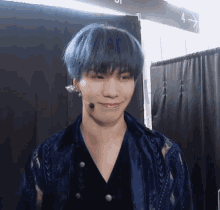 a man with blue hair is standing in front of a sign that says a1