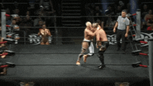 two men in a wrestling ring with a referee in the background