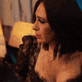 a woman in a black lace top has blood on her face
