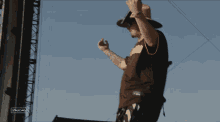 a man wearing a cowboy hat and a stagecoach shirt