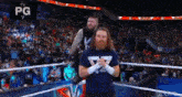two men are standing in a wrestling ring .