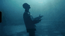 a silhouette of a man in a dark room looking up