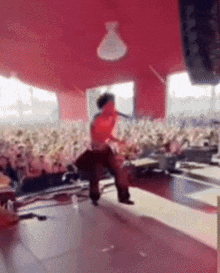 a man is singing into a microphone on stage in front of a crowd