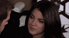 a man and a woman are looking at each other and the woman is looking at the man .