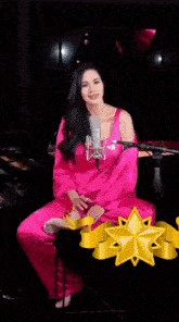 a woman in a pink dress singing into a microphone in front of a trophy that says ' marin ' on it