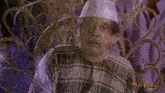 a man wearing a plaid shirt and a white hat is sitting in a chair with the word man laying on the bottom right