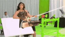 a woman in a wonder woman costume is holding a sword in a studio .