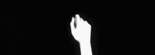 a black and white photo of two hands holding each other 's fingers .