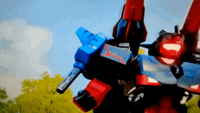 a red and blue robot with a gun on it 's back