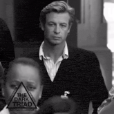 a black and white photo of a man with the dark triad logo