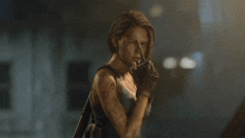 a woman holding a gun and a walkie talkie in her hand