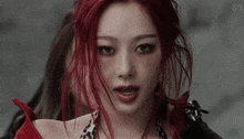 a close up of a woman 's face with red hair .