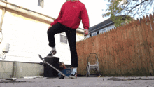 a person wearing a red sweatshirt with the word adidas on it stands on a skateboard