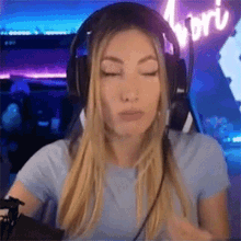 a woman wearing headphones and a microphone is sitting in front of a computer .