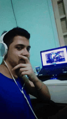 a man wearing headphones is looking at a laptop
