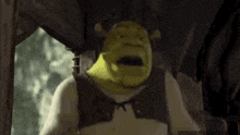 shrek is looking out of a window and making a funny face .