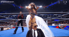 a woman in a white dress is standing in a wrestling ring