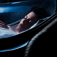 a person is laying in a container with a hose attached to it