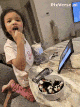 a little girl sitting at a table with a bowl of food and a tablet with pixverse.ai written on the bottom