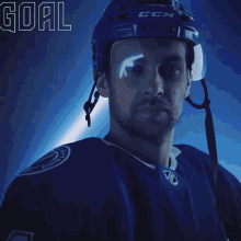 a hockey player wearing a ccm helmet stands in front of a lightning bolt