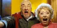 a man and a woman are standing next to each other with their mouths open in a blurry photo .
