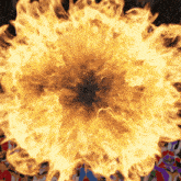 a large explosion of fire is surrounded by a crowd