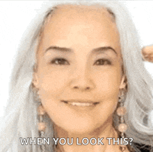 a woman with gray hair is smiling and asking when you look this ?