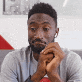 a man with a beard is wearing ear buds and looking at the camera
