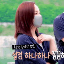 a woman wearing a face mask is standing next to a man in a blue shirt
