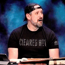 a man wearing a black shirt that says cleared hot on it