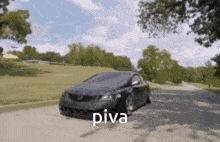 a black car is driving down a road with the word piva written on the bottom