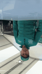 a man wearing a green jacket that says boss on it is upside down