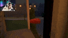 a man wearing headphones is playing a video game with a red object in the background