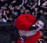 a man in a red sweater is surrounded by a crowd of people
