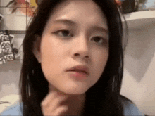 a close up of a woman 's face with a hand on her chin .