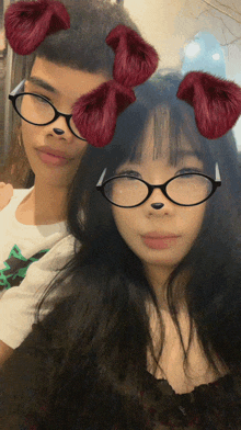a boy and a girl wearing glasses with red bows on their heads