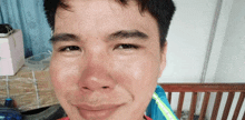 a close up of a man 's face with a green stripe on his shirt that says asics
