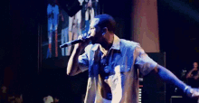 a man singing into a microphone on stage