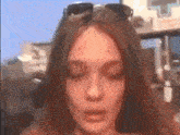a woman wearing sunglasses looks down with her eyes closed