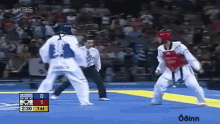 a man in a red helmet is fighting another man in a white uniform .