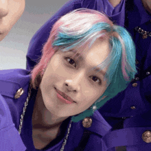 a person with blue and pink hair is wearing a purple shirt