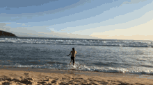a man is running out of the ocean on a beach