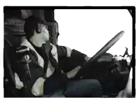 a man wearing headphones and a hat is driving a truck with the words made with on the bottom right