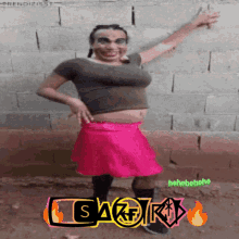 a woman in a pink skirt is standing in front of a brick wall with the word sakir on the bottom
