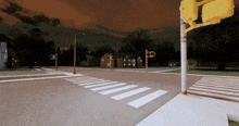 an intersection with a crosswalk and a traffic light at night